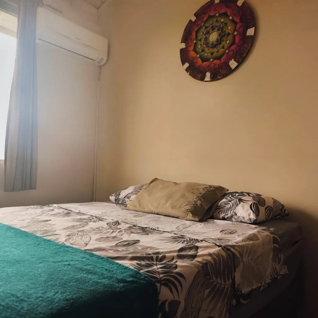 Cama de casal com mandala na parede e ar-condicionado