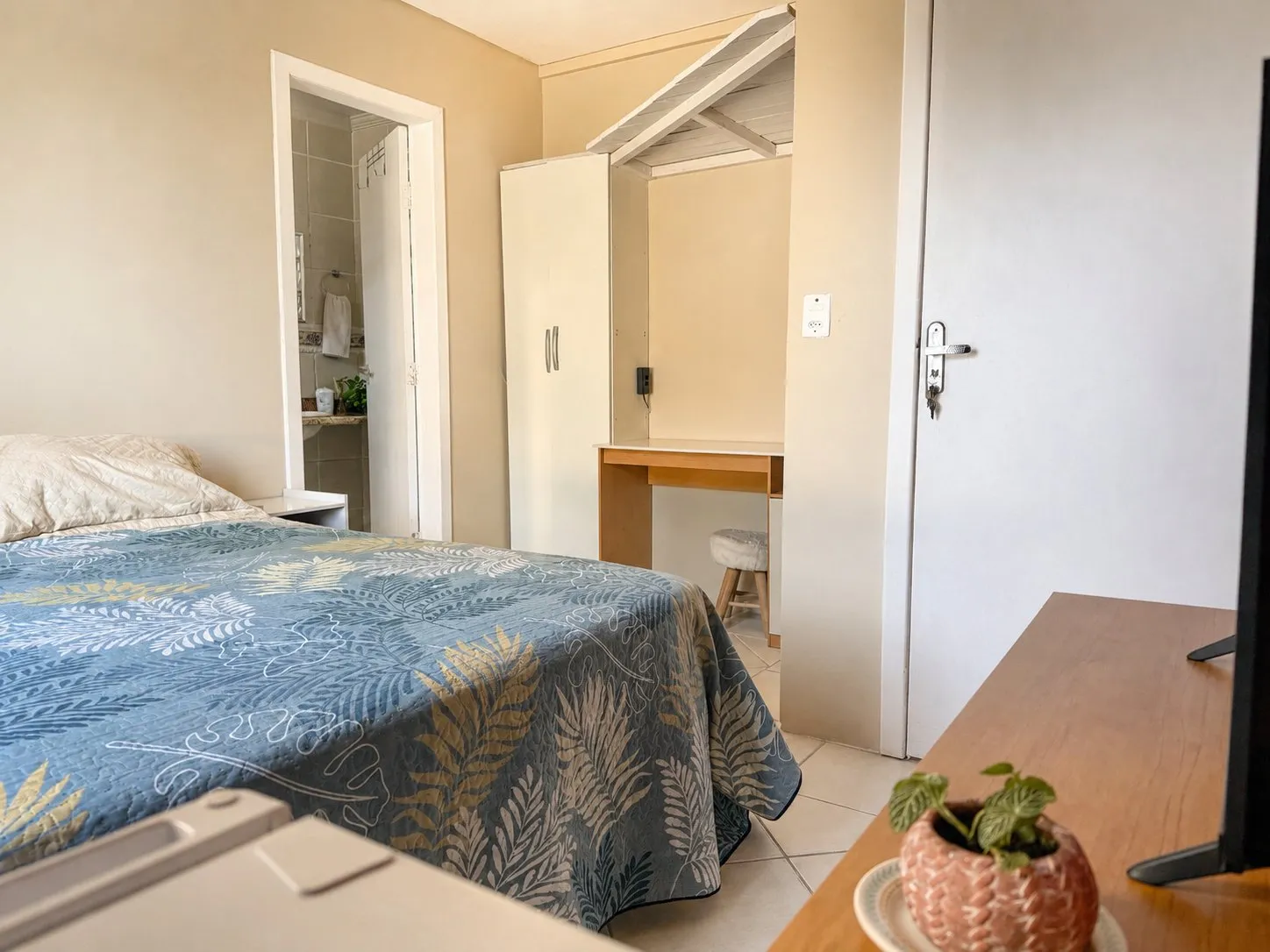 Cama de la Suite Santinho con escritorio al fondo